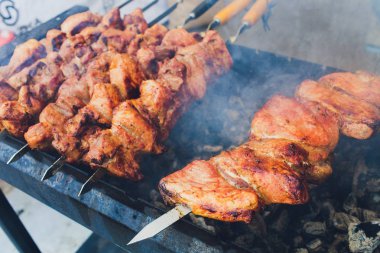 Metal şişte pişen ızgara kebap. Barbeküde pişmiş et. Barbekü taze et dilimleri. Geleneksel doğu yemeği, şiş kebap. Kömür ve alevler üzerine ızgara, piknik, sokak yemekleri.