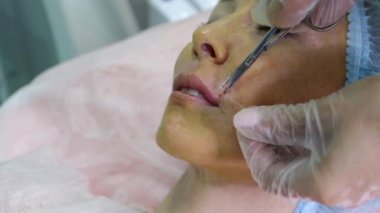 Güzel kadın üst dudak iplik bir el yakın.