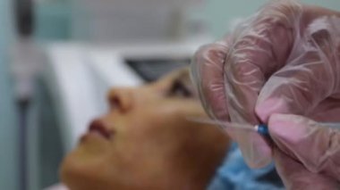 Güzel kadın üst dudak iplik bir el yakın.