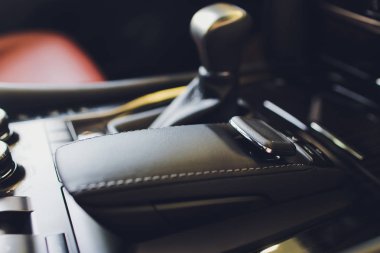 Modern bir araba otomatik vites sopa şanzıman, multimedya ve navigasyon kontrol düğmeleri. Araba iç detayları. İletim kayması.