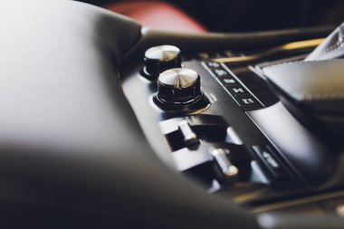 Modern bir araba otomatik vites sopa şanzıman, multimedya ve navigasyon kontrol düğmeleri. Araba iç detayları. İletim kayması.