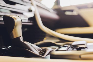 Modern bir araba otomatik vites sopa şanzıman, multimedya ve navigasyon kontrol düğmeleri. Araba iç detayları. İletim kayması.