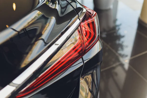 Achteraanzicht van de nieuwe zwarte auto. Closeup koplampen van de auto. Zwarte premie stad crossover, luxe Suv achterste lichte close-up. Auto lamp close-up. — Stockfoto