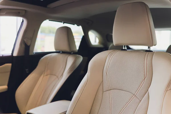 Car inside driver place. Interior of prestige modern car. Front seats with steering wheel dashboard. Beige cockpit with metal decoration panoramic roof on isolated white background.