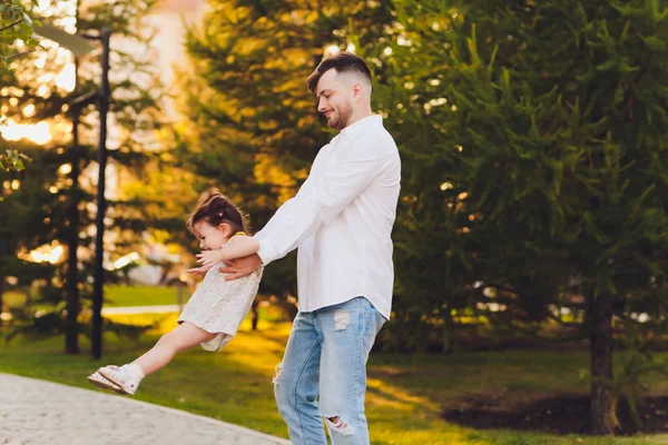 Vaderschap, familie en Leisure concept-vader Holding kleine dochter in zijn armen in Park. — Stockfoto