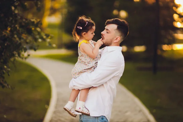 Vaderschap, familie en Leisure concept-vader Holding kleine dochter in zijn armen in Park. — Stockfoto