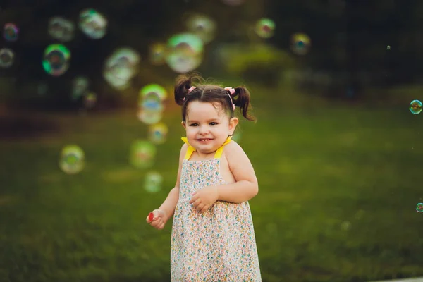 Het beeld van een schattig klein meisje met bubbels. — Stockfoto