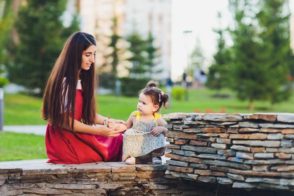 Щасливі матері і дочки сидять на лавці в міському парку . — стокове фото