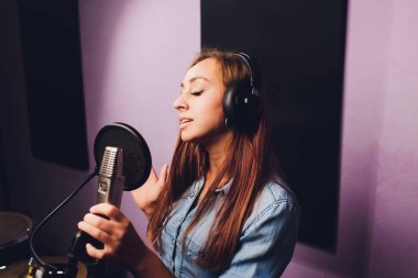 Stüdyoda şarkı kaydeden bir şarkıcıya yakın çekim.