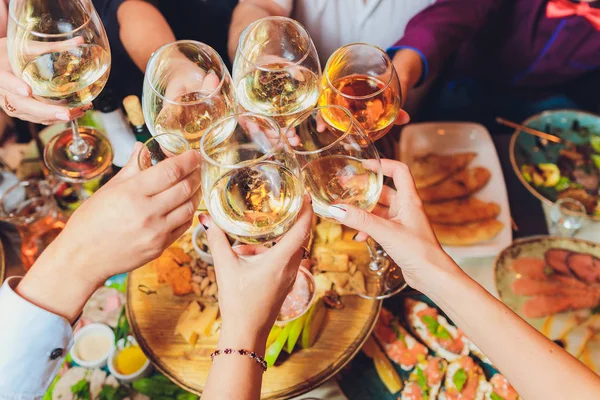 Крупним планом знімок групи людей, що чіпляються за келихи з вином або шампанським перед фоном боке. літні люди руки — стокове фото