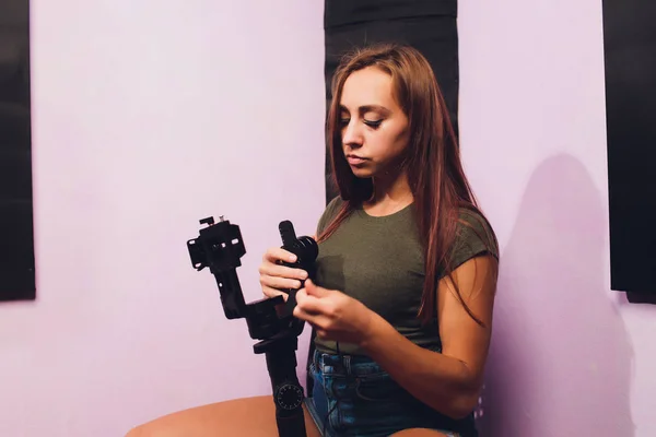 Young woman using a gimbal camera stabilizer to take footage inside a house. Filming different antiques using a professional modern mirrorles camera.