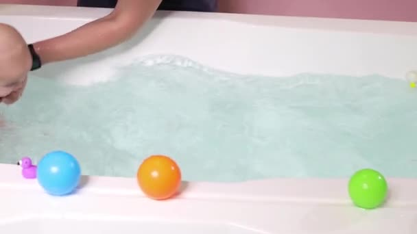 A father helps is infant boy during swimming lessons in the pool. — Stock Video