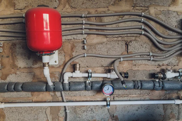 Primer plano de manómetro, tuberías y válvulas de grifo del sistema de calefacción en una sala de calderas. — Foto de Stock