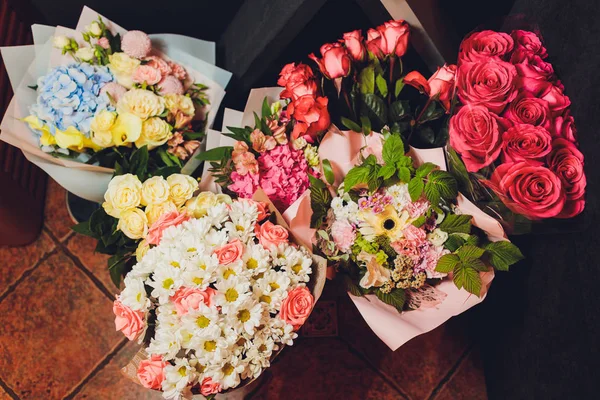 Bouquets de flores no chão em frente a uma loja de flores com lírios, girassóis, cravos, estatísticas e muito mais . — Fotografia de Stock