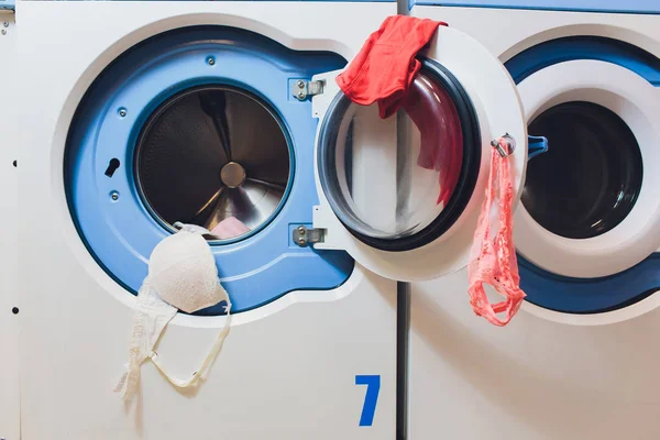 Mulher tomando roupas coloridas da máquina de lavar roupa . — Fotografia de Stock