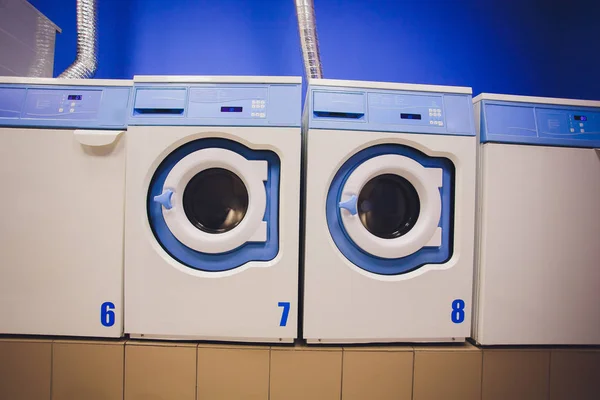 Professional washing machines with baskets full of clothes at the self-service laundry. — Stock Photo, Image