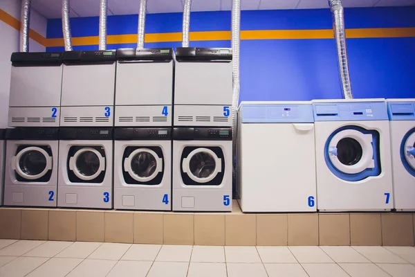 Mesin cuci profesional dengan keranjang penuh pakaian di binatu swadaya . — Stok Foto
