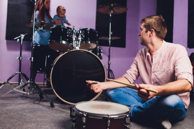 küçük çocuk bateri kayıt stüdyosunda çalıyor..