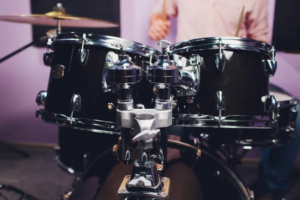 Joven detrás de una instalación tipo tambor en un estudio de grabación profesional . — Foto de Stock