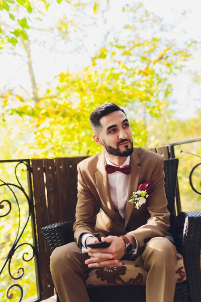 Happy handsome bearded groom in suit with a restaurant in background. — Stock Photo, Image