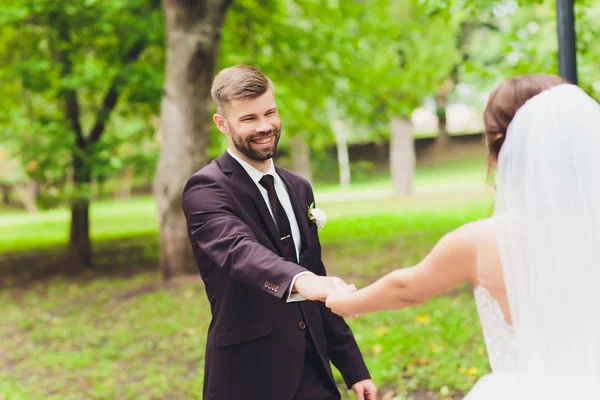 Šťastný ženich a nevěsta v parku na jejich svatební den. — Stock fotografie