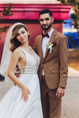 Şık mutlu gelin ve damat açık havada düğün resepsiyonda akşam ışığında büyük aşk kelime poz. Akşam parkında eğlenmek yeni evlilerin Muhteşem düğün çift.