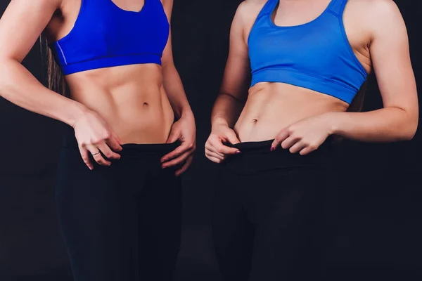 The belly of a slim woman close up. Female press. A drop of sweat on a thin sports stomach. Training on the climbing wall. Strong female hands. Woman trained in the gym. — Stock Photo, Image