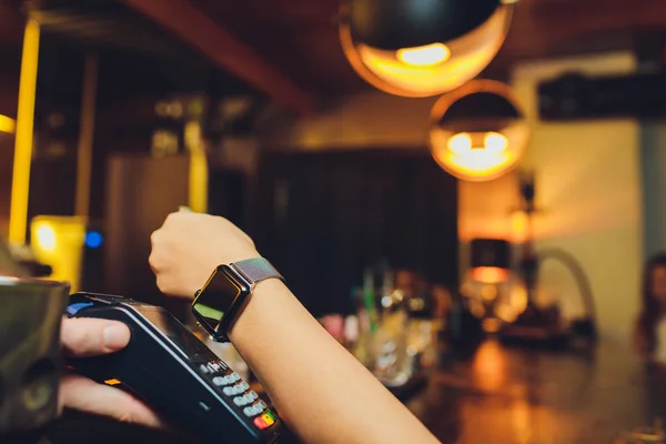 利用NFC技术，妇女通过智能手表支付工资. — 图库照片