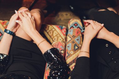 Kendi seçtikleri ile kendinden emin. Ayakkabı mağazasında kanepede otururken dize bölümü mükemmel bacaklar bacaklarını tutmak olan genç kadın geçti.