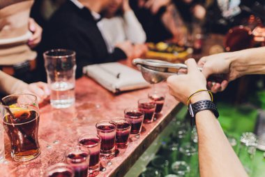 Barmen güçlü alkollü içecek bar, çekim küçük gözlük içine dökme.