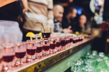 Barmen güçlü alkollü içecek bar, çekim küçük gözlük içine dökme.