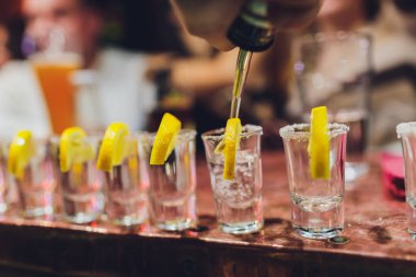 Barmen güçlü alkollü içecek bar, çekim küçük gözlük içine dökme.