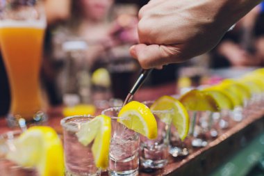 Barmen güçlü alkollü içecek bar, çekim küçük gözlük içine dökme.