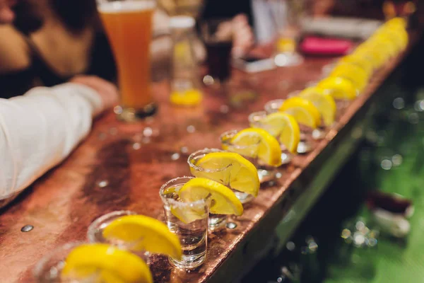 Barmen güçlü alkollü içecek bar, çekim küçük gözlük içine dökme.