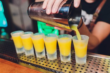 Barmen güçlü alkollü içecek bar, çekim küçük gözlük içine dökme.