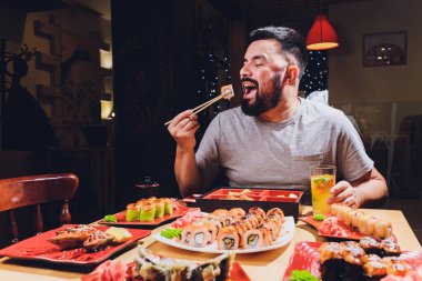Asyalı yemek yiyen turist yerel kafe, yemek çubuğu kullanarak gülümse..