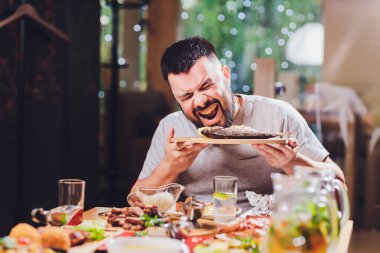 Büyük masada yemekli bir adam var..