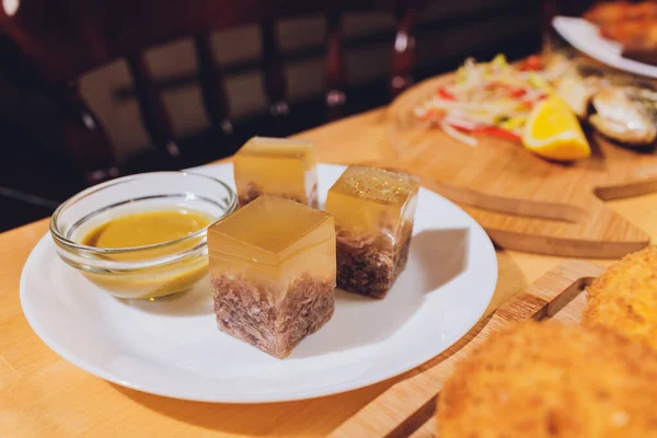 Gelatinado, aspic cozido de carne bovina, carne de porco, frango com mostarda em um prato close-up . — Fotografia de Stock