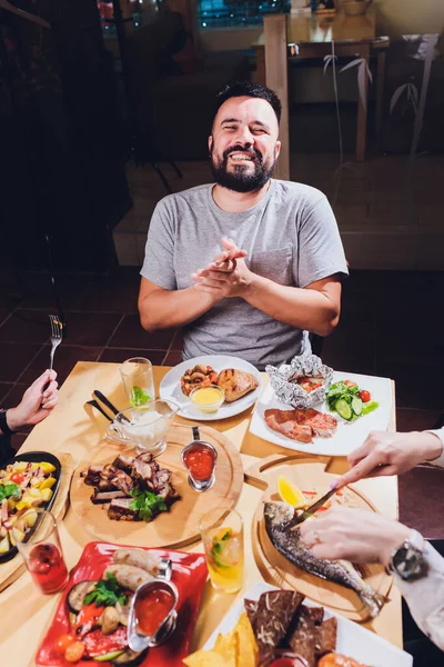 Hombre en la gran mesa con comida . — Foto de Stock