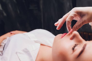 Kozmetolog hastaların yüz kasları bir bukkal masaj yapar.