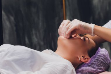 Kozmetolog hastaların yüz kasları bir bukkal masaj yapar.