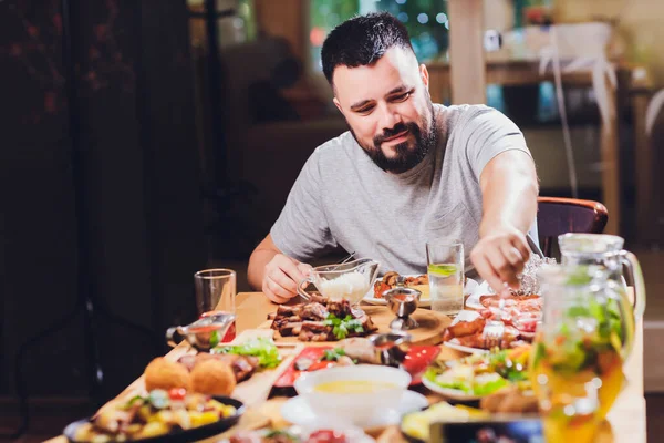 Человек за большим столом с едой . — стоковое фото