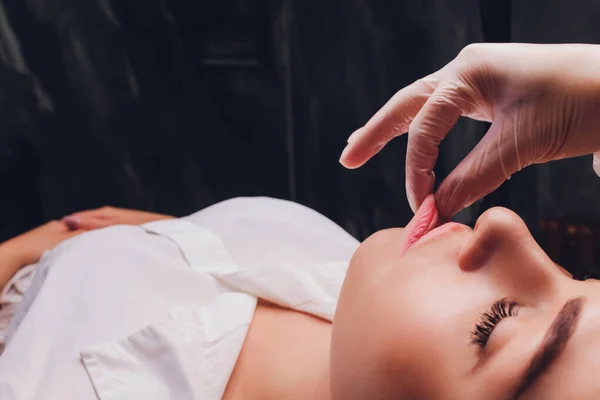 Cosmetólogo hace un masaje bucal de los pacientes músculos faciales . —  Fotos de Stock