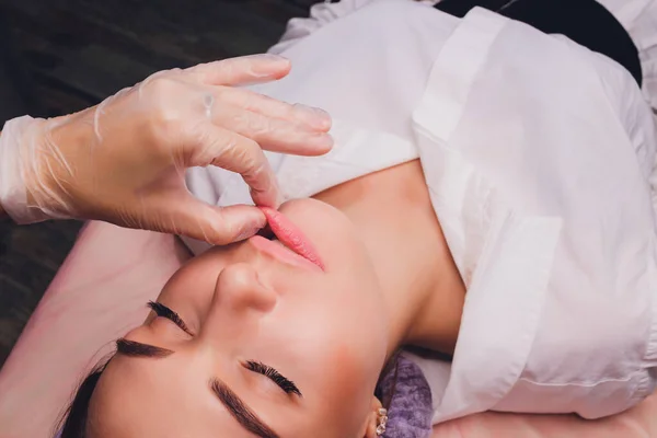Kosmetolog sprawia, że masaż policzkowy pacjentów mięśnie twarzy. — Zdjęcie stockowe