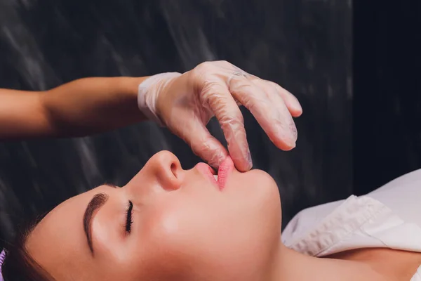Cosmetólogo hace un masaje bucal de los pacientes músculos faciales . — Foto de Stock
