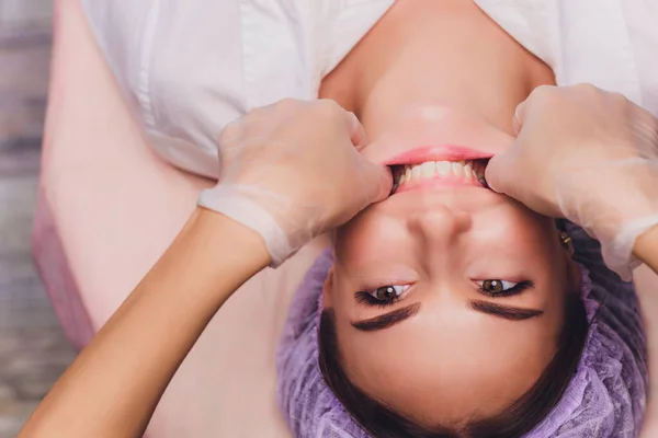 Cosmetologist faz uma massagem bucal dos músculos faciais dos pacientes . — Fotografia de Stock