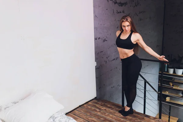 Çekici fitness kadını spor salonuna gitmeden sağlıklı bir yaşam tarzının bir parçası olarak evde esneme egzersizleri yapıyor.. — Stok fotoğraf
