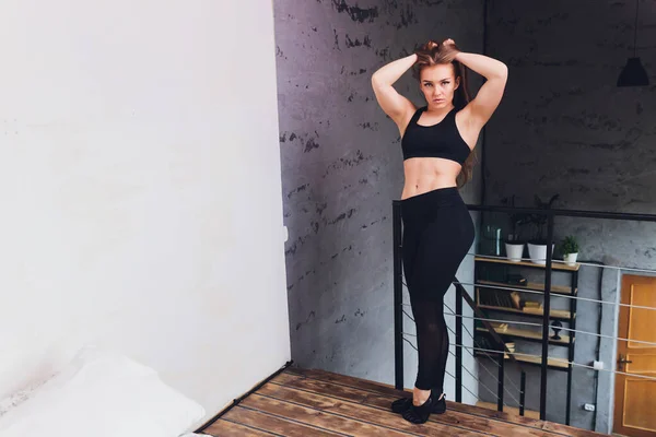 Attrayant fitness femme faire des exercices d'étirement à la maison, dans le cadre d'un mode de vie sain sans aller à la salle de gym . — Photo