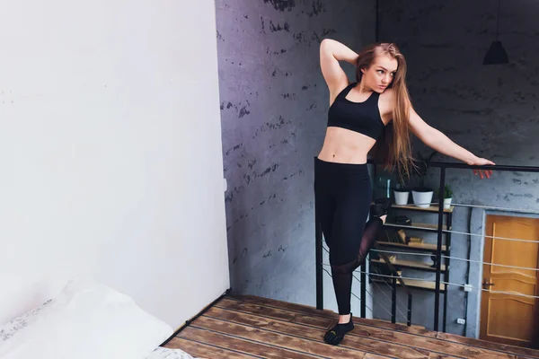 Atractivo fitness mujer haciendo ejercicios de estiramiento en casa, como parte de un estilo de vida saludable sin ir al gimnasio . —  Fotos de Stock