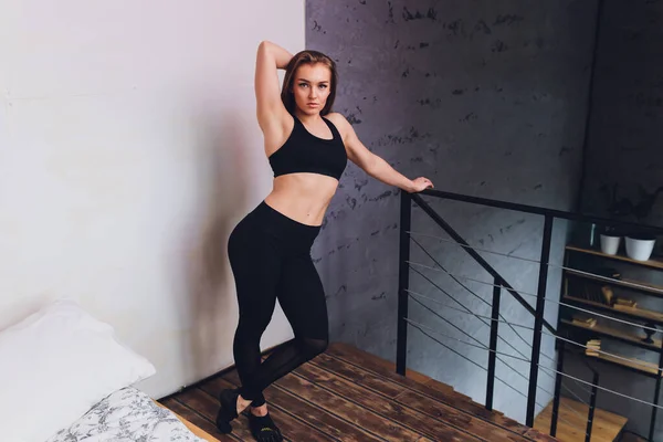 Attrayant fitness femme faire des exercices d'étirement à la maison, dans le cadre d'un mode de vie sain sans aller à la salle de gym . — Photo